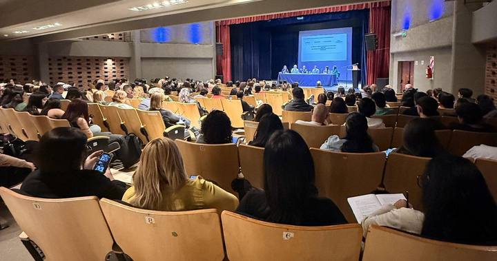 Panel de disertantes ante un auditorio colmado